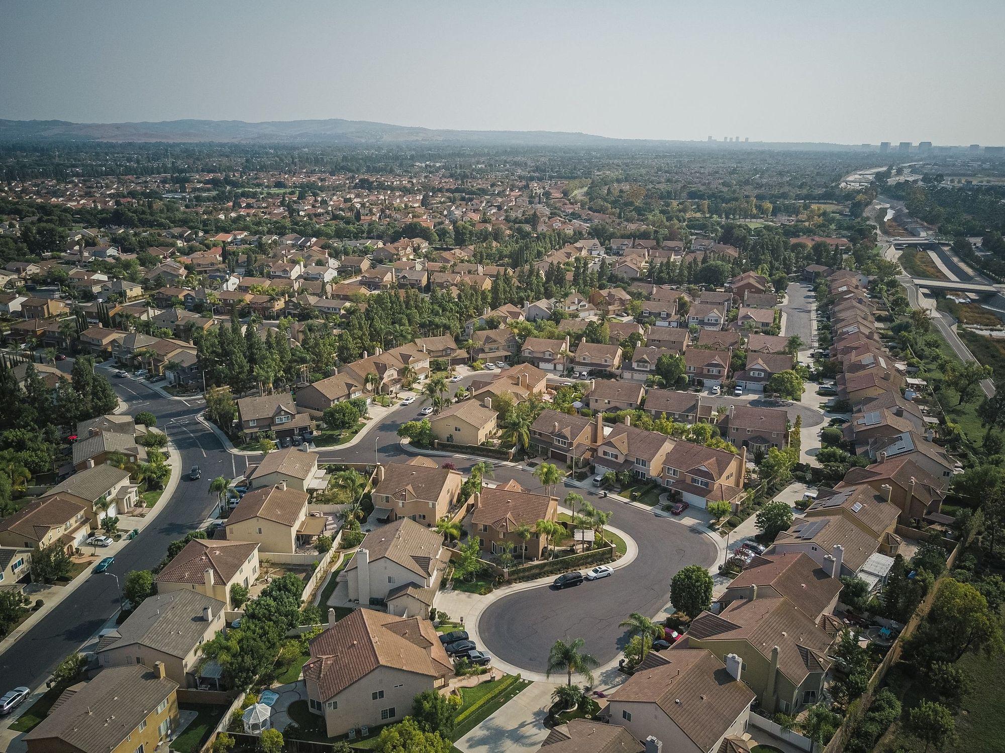 Aerial view of a suburb with rows of two-story homes on curving streets