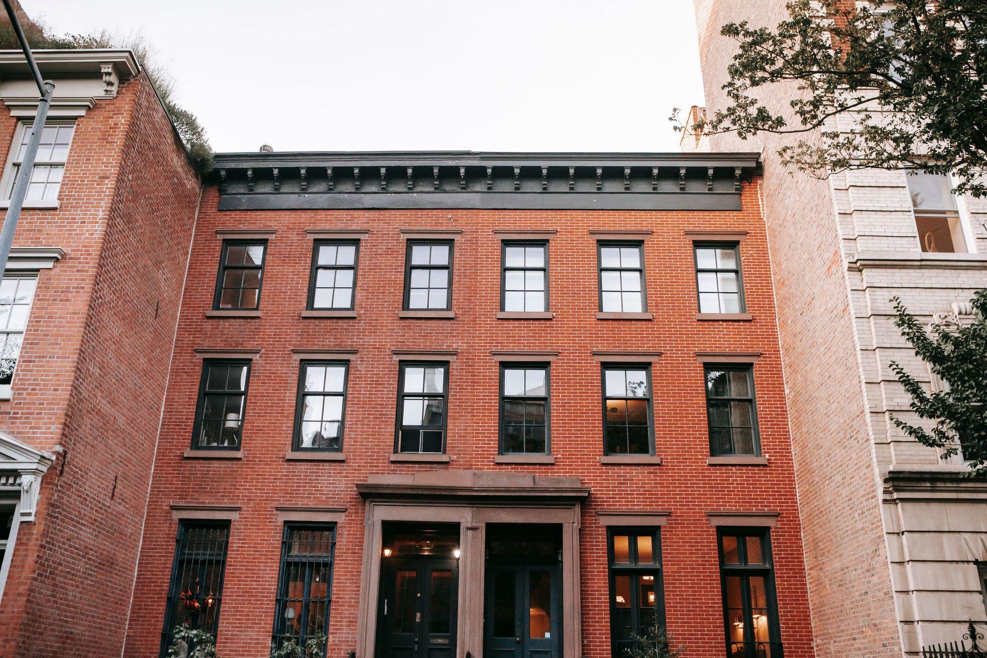 A three-story red brick apartment building with black-framed windows